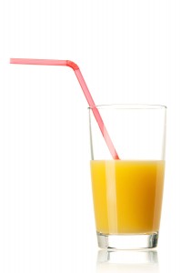 Glass of fresh orange juice with straw on white background